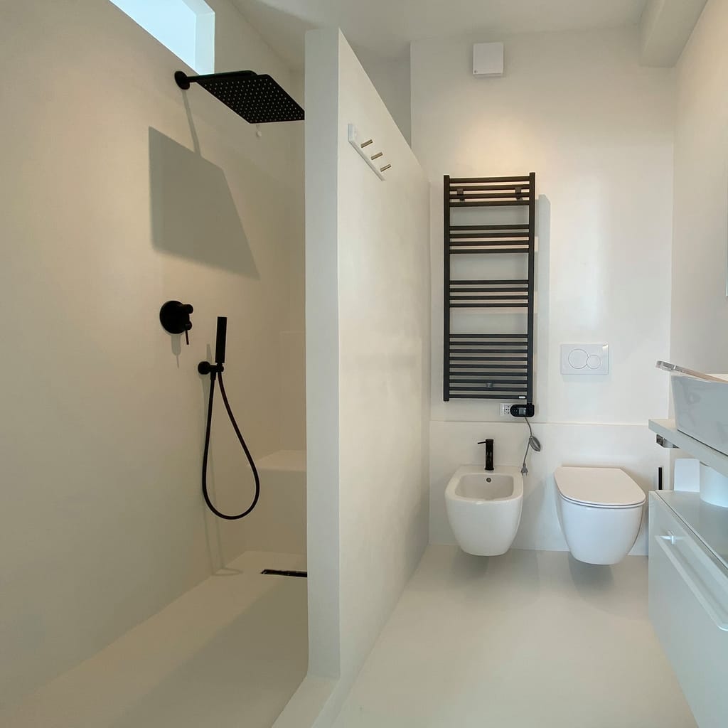 Salle d'eau contemporaine — microciment continu, douche à l'italienne.